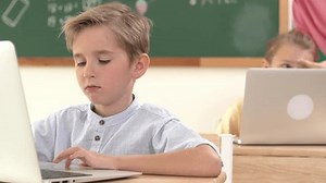 Caucasian boy working at laptop while diverse children programing software system. Teacher and student looking at boy laptop screen to solve problems and support coding engineering prompt. Pedagogy.