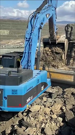 Blue Caterpillar 345C Excavator Loading Trucks