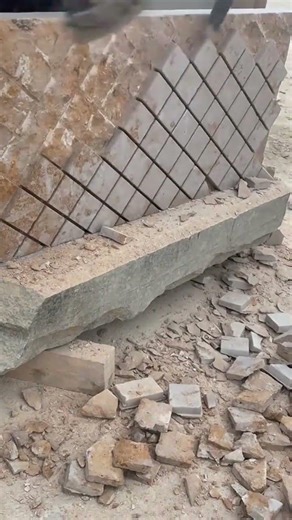 carving diamond patterns on a large stone block using a hand tool for professional construction