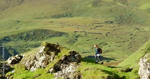 Nature, hiking and woman in mountain with lake, adventure and vacation travel with green environment. Walking, wellness and girl on cliff for trekking, journey and climbing holiday with lake on hill.