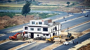 China y el raro caso de las “casas clavo”: atrapadas en medio de autopistas