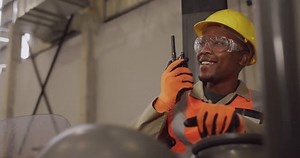 Animation of network of icons over african american worker using walkie talkie. Global connections, computing and data processing concept digitally generated video.