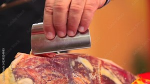 Cutting leg of dried pork meat. Cutting Iberian Ham on a stand. Leg of ham cut with knife