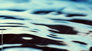 Water surface dark blue texture with clean ripples and wave refraction background. Slow motion