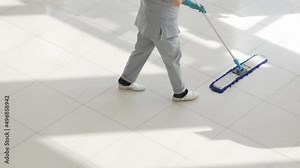 a female cleaner washes floors with a mop in the office or sales floor.