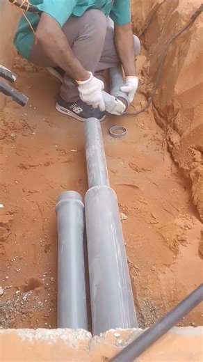 cutting pvc pipe using a grinder tool inside the trench
