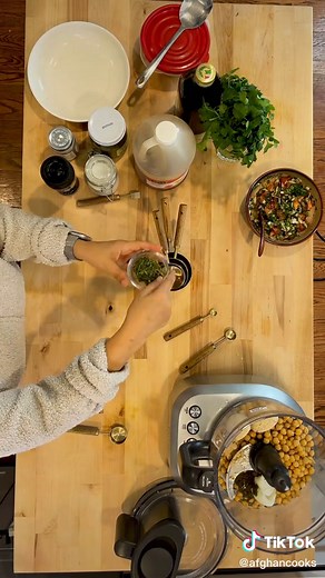 Afghan recipe hack again. Afghans eat a cold chickpea salad called Shor Nakhod. This takes all those flavors and makes it into a vegan dip. Pls save and share! Ingredients 1 Small Potato Boiled / Peeled I Can Chickpeas (drained) 1/2 Teaspoon Garlic Powder (used Burlap and Barrel of course) 1/2–3/4 Teaspoon of Salt 2–4 Tablespoons of Apple Cider Vinegar 1/2 Bunch Cilantro 1 Tablespoon Dried Mint Olive Oil Salata for Topping Crispy Vegetables or Chips to Dip Steps 1. Place all of your ingredients 