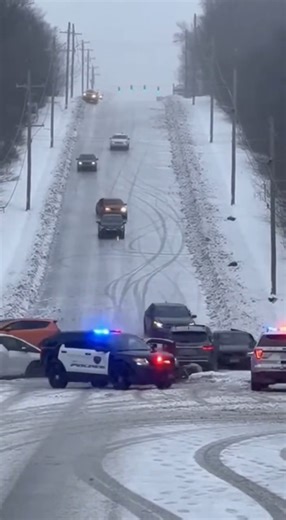 Icy Hill Becomes Unstoppable Slide as Cars Lose Control One After Another Midwestern United States — A steep roadway turned into a sheet of ice and chaos after winter conditions caused multiple vehicles to lose traction and slide uncontrollably downhill. Footage from the scene shows cars attempting to descend the hill slowly, only to begin drifting sideways as tires fail to grip the frozen pavement. One vehicle spins completely around and slides into the shoulder, narrowly missing a utility pole