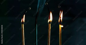 Four matches are burning and then one match extinguishes, and soon after three more. We can see a smoke slowly diminishing. Close-up shot.