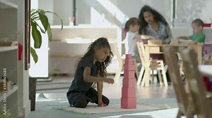 Learning time. A teacher runs a lesson with a diverse group of young children in a beautiful modern classroom. Back to school learning. Shot in 4k.