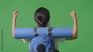 Close Up Back View Of A Female Hiker With Mountaineering Backpack Looking Around While Walking On Green Screen Background In The Studio