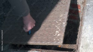 Opening and closing a manhole cover over a domestic sewer with manhole keys