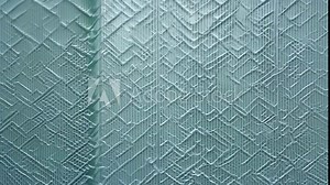 Creating textured wall art in a light blue pattern at a creative studio in the afternoon