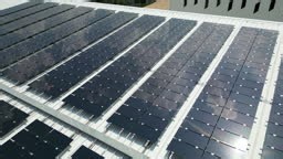 Aerial view solar panels on buildings roof during Sunny Day.