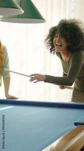 Friends laughing when woman playing awful at pool