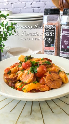 Creamy Sausage & Tomato Pasta Recipe! This tasty meal comes together in one pan making clean up super easy! Ingredients: 2 tbsp olive oil 14 oz smoked sausage, sliced 1 cup chopped onion 2 bell peppers, chopped 3 cloves garlic, minced Salt & pepper, to taste 1/2 tsp crushed red pepper 8 oz pasta of choice 3 cups chicken stock 15 oz can diced tomatoes 1 tbsp tomato paste 1/2 cup heavy cream 3 cups spinach 1/2 cup grated Parmesan cheese 6 oz cherry tomatoes Parsley for garnish Instructions: Heat o