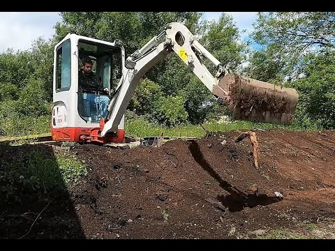 Digging a garden and making a bank with a mini digger Takeuchi TB216 Excavator