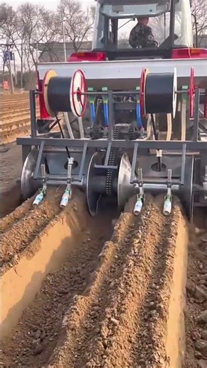 operating a tractor to install drip irrigation pipes and create soil ridges for planting