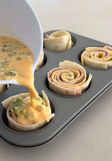 I wasn’t expecting these to be this good. Crispy edges, soft cheesy middle and they hold together perfectly for lunches, snacks or an easy dinner. Just stack, roll, slice and bake. No fuss, no mess. They’re also one of those “use what you’ve got” recipes, swap the ham, change the cheese, add whatever you need to use up. Ingredients 3 large wraps 6 slices ham 6 slices cheese 4 eggs ¼ cup cream 2 tablespoons chives or spring onion, finely sliced ½ cup grated cheese, extra for top Method \t1.\tPreh