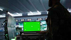 Army specialist working in war room operating surveillance tech, evaluating target data on isolated screen laptop. Soldier engaging enemy forces using chroma key notebook, camera B