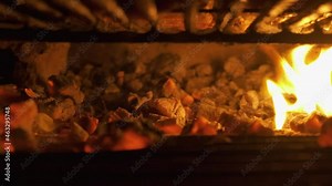 Camera captures the fire built-up inside an active furnace with a bed of charcoal and wooden pieces as fuel.