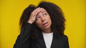 Unwell woman touching forehead on yellow background