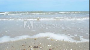 sea waves rolling to the sandy beach. Close-Up of Waves and Sand on The Beach.
