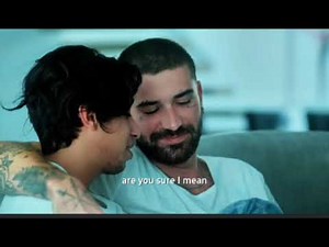 Gay men watching horror movie at home kissing hugging poking each others . Gay marriage . Gay love