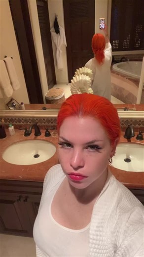 Bright Orange Hair Transformation in Stylish Bathroom