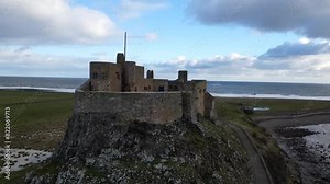 Drone footage of the Lindisfarne Castle crowned a coastal crag on Holy Island, England, UK