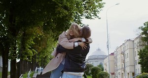 A man and woman hugging on the street