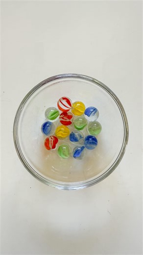 Lindsey BenGera | Sprinkle in Learning® on Instagram: "Marble Drop 🟡🟣🟢 A fun diy steam game using simple materials. How many marbles can you stack on before they fall into the cup? Why do the marbles fall through the paper towel? (Note: the key is to make sure the marbles are wet so they eventually break through the paper towel.) #sprinkleinlearning #diygame #marbles #marblerun #marblegame #diygame #gamesforkids #kidsgames #kidsgame #activityforkids #game #activities #simpleactivities #timeto