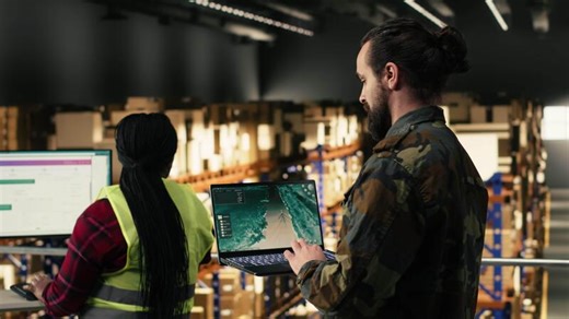 Military personnel using advanced military surveillance interface in warehouse, aerial footage monitoring for threat detection. Armed forces distribution, storage infrastructure and coordination.