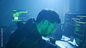 Profile of serious handsome programmer designing a software writing code working computer in the office.