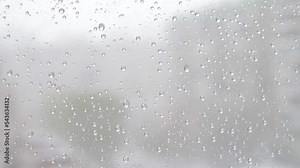 Window glass background during sleet.close-up of a drop of snow melting on the window glass. Snowfall outside the window.bad weather thaw melting snow on the window .selective focus