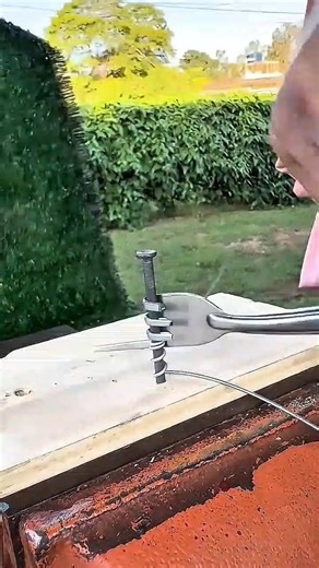 wrapping the thin metal wire around the long steel nail using a metal fork for the creative activity