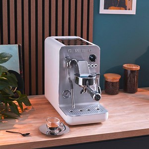 Introducing the Minipro Espresso Coffee machine – professional-level performance in a compact, user-friendly package. Made in Italy for that authentic espresso experience, it brings café-quality coffee into your home. With a rapid-heating triple thermoblock system, a powerful 15-bar pump, and a stainless steel steam wand for velvety foam, your perfect espresso awaits, right at your fingertips. | Smeg