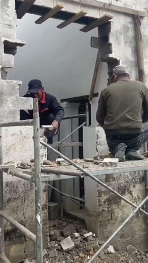 demolishing a concrete wall precisely to create a window opening using a manual hammer and chisel