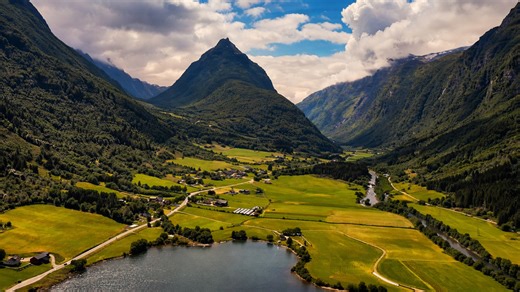A natural valley landscape with bright fields and towering peaks