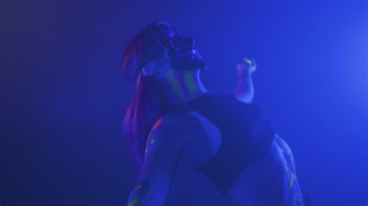 Girl with a mask dancing under a party light - Free Stock Video