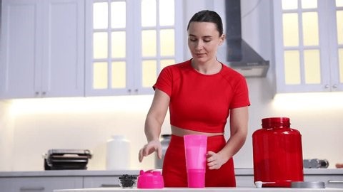 clip-4002670503-woman-making-protein-shake-table-kitchen