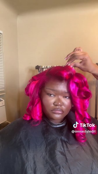 Pink hair sew-in with layers and curls by Detroit stylist