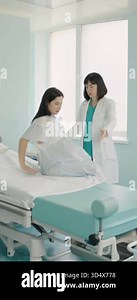 A pregnant woman is examined by a doctor in a hospital room, preparing for a medical procedure. Vertical video Stock Video Footage - Alamy