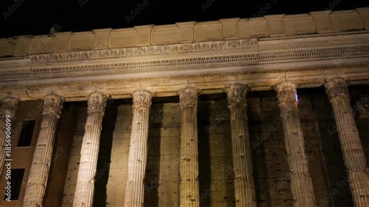 night time ancient roman temple facade fluted corinthian columns carved entablature golden light weathered stone glows piazza di pietra / hadrian up close rome italy empire