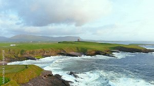 Spectacular aerial sunset view of Mullaghmore Head with huge waves rolling ashore. Picturesque scenery with magnificent Classiebawn Castle. Signature point of the Wild Atlantic Way, Co. Sligo, Ireland