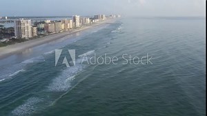 Aerial pan east to west from the Atlantic ocean over high rise condos and residential houses to the Halifax river, Daytona Beach Shores, Volusia county, Florida, USA.