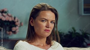 A beautiful woman in an angry state looks at the camera with disappointment. Woman with an angry expression. Face, stress and scream for emotional expression