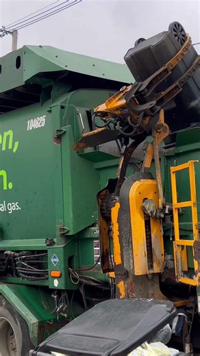 WM Garbage Truck Packing A 64 Gallon Toter.