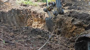 Backhoe to excavate the trench on the ground.The bucket of crawler excavator with full of soil is lifting from agriculture field,hd slow motion.