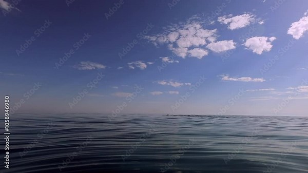 A serene scene depicts an elderly woman swimming in the calm sea near a beach under a clear blue sky, highlighting tranquillity and adventure in nature.